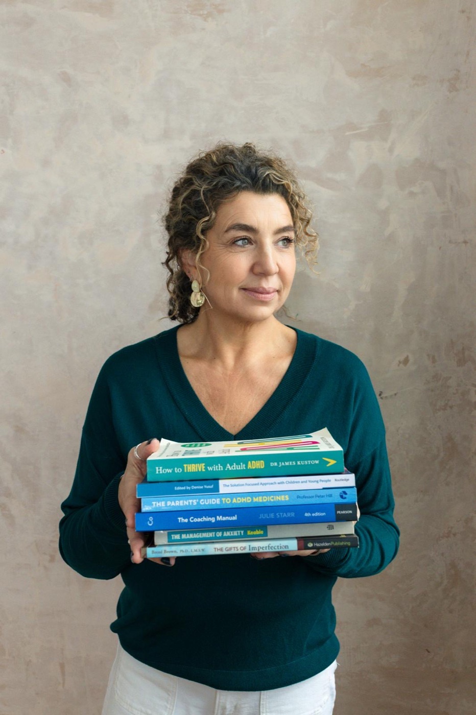 Jill Martin holding a stack of therapy and occupational therapy books